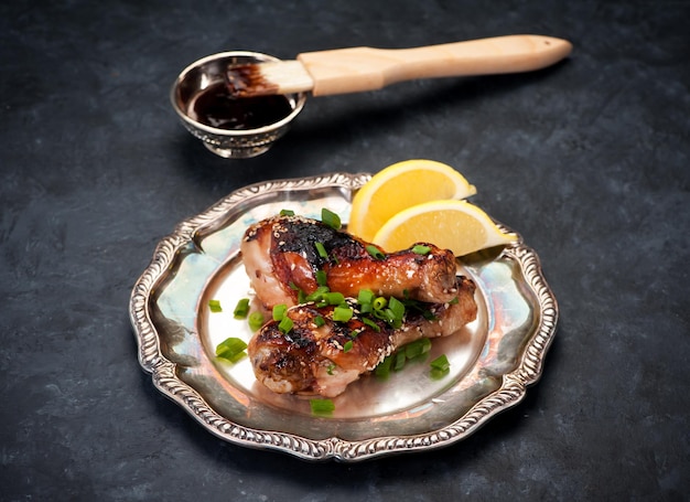 Smażone udka z kurczaka z sosem teriyaki w srebrnym talerzu vintage