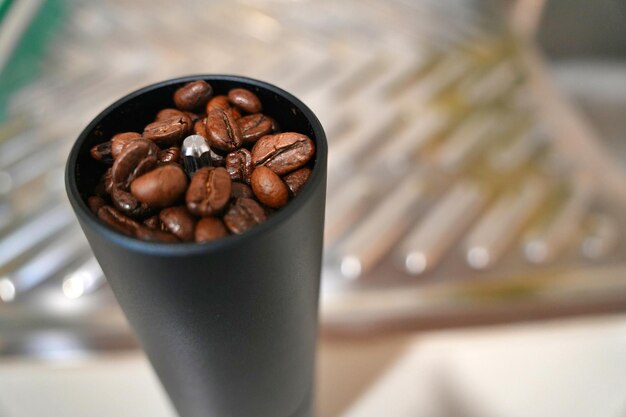 Zdjęcie smażone ziarna kawy spadają do ręcznej młynki.