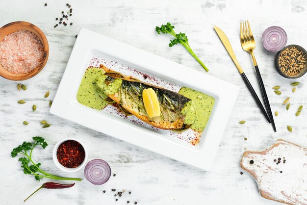 Zdjęcie smażony filet z makreli z warzywami cytrynowymi na białym talerzu widok z góry styl rustykalny