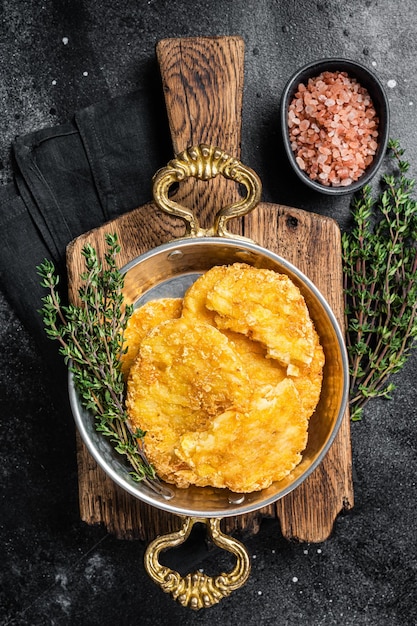 Smażony hash brązowy ziemniaczany hashbrown na patelni Czarne tło Widok z góry