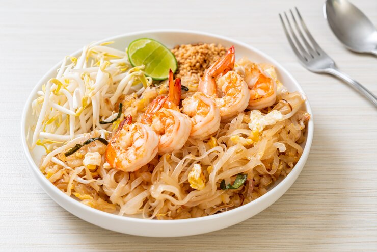 Zdjęcie smażony makaron z krewetkami i kiełkami lub pad thai - po azjatycką kuchnię