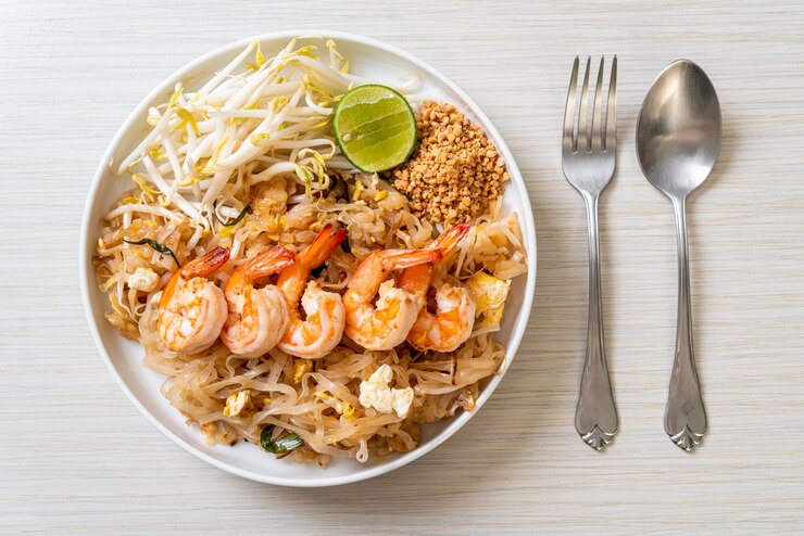 Zdjęcie smażony makaron z krewetkami i kiełkami lub pad thai - po azjatycką kuchnię