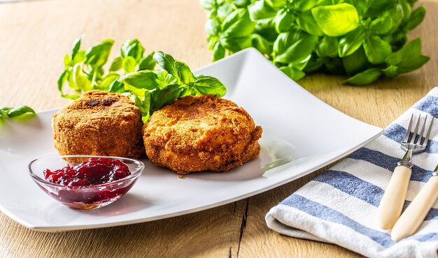 Smażony ser camembert lub brie z konfiturą żurawinową i bazylią.