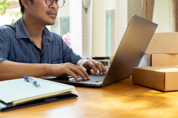 SME biznesmen pracuje na laptopie z pakuneczka pudełkiem na stole