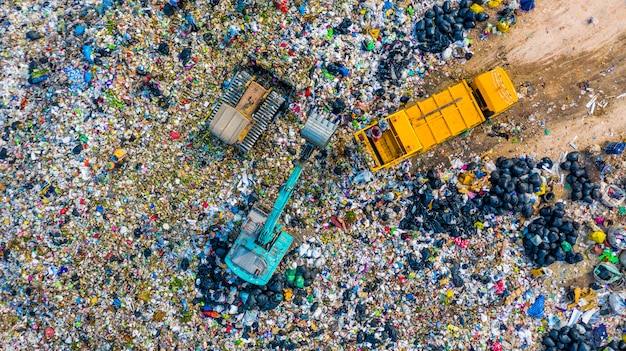 Śmieci na wysypisku śmieci lub wysypisku śmieci, widok z lotu ptaka śmieciarki rozładowują śmieci na wysypisko śmieci, globalne ocieplenie.