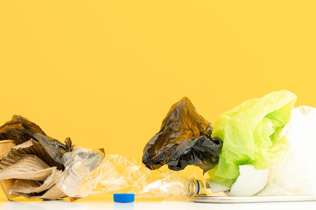 Śmieci nadające się do recyklingu składające się ze szkła, plastiku, metalu i papieru na żółto