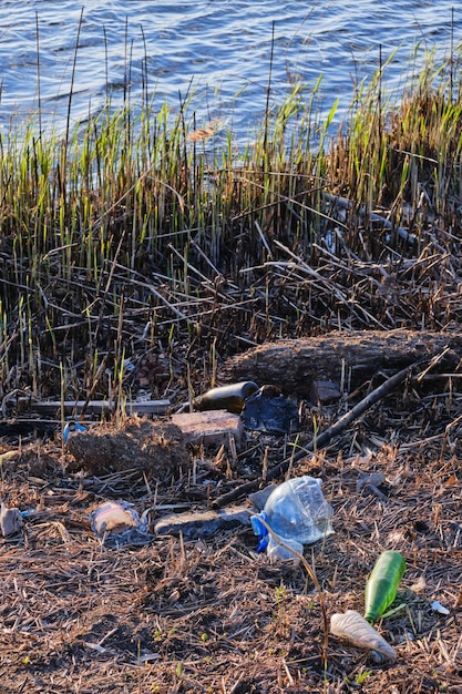 Śmieci z tworzyw sztucznych i szkła zanieczyszczenie brzegów rzeki środowisko i przyroda