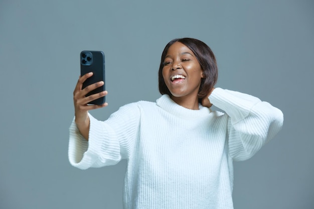 Śmiejąca Się Piękna Afroamerykańska Młoda Blogerka Robiąca Zdjęcie Selfie Na Telefonie W Celach Społecznościowych