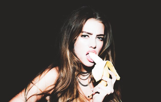 Śmieszna młoda kobieta jedzenie bananowych owoców tropikalnych koncepcja lato zdrowe odżywianie flirtowanie randki romant