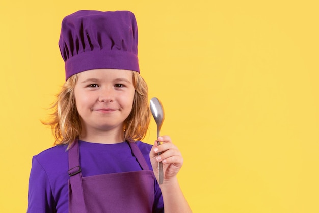 Śmieszne dziecko kucharz z łyżką portret studyjny Portret małego dziecka w mundurze kucharza Chłopiec szefa kuchni odizolowany na tle studia Słodkie dziecko być szefem kuchni Dziecko przebrane za kapelusz