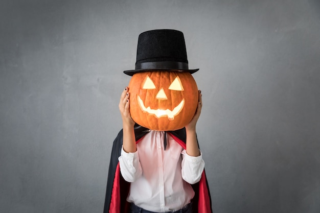 Śmieszne dziecko ubrane w kostium na Halloween. Dzieciak namalował strasznego wampira. Jesienna koncepcja wakacji