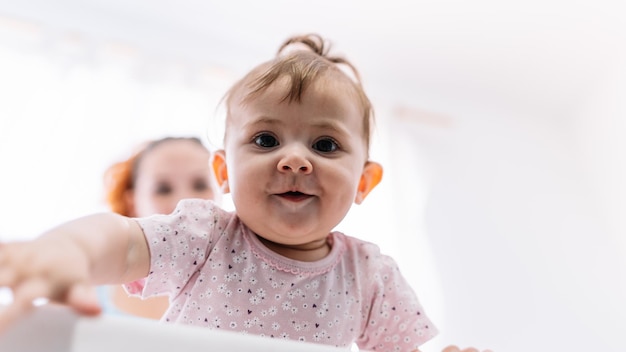 Zdjęcie Śmieszne dziecko w kołysce obok mamy