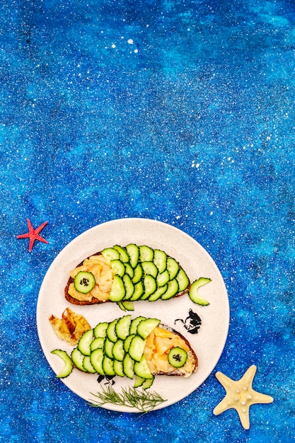 Śmieszne kanapki z łososiem z ogórkiem w kształcie ryby