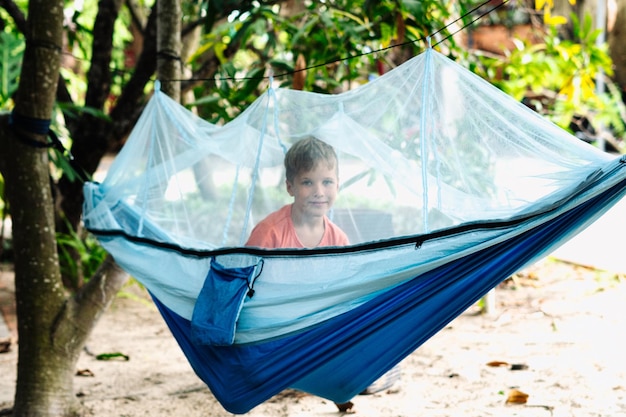 Smile dziecko chłopiec leżeć reszta hamak z moskitierą Happy dzieciństwa marzeń Spójrz na z śmiechem Portret