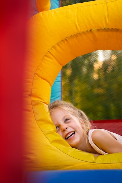 Smiley dziewczyna w bounce house średni strzał