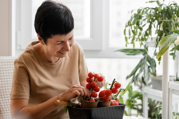 Zdjęcie smiley kobieta dba o kryty pomidora