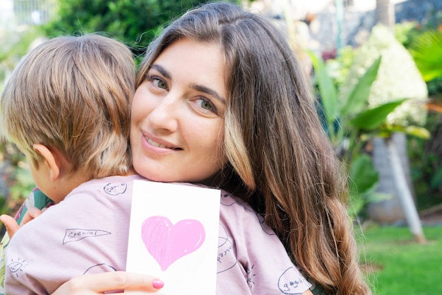 Smilling Matka Przytulanie Z Synem W Letnim Ogrodzie, Dzień Matki I Koncepcja Szczęśliwego Rodzinnego Stylu życia