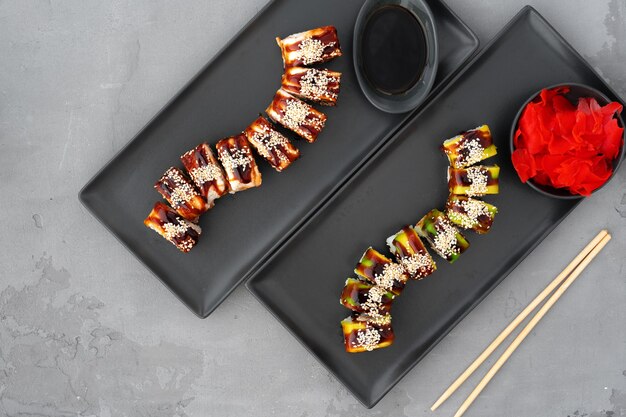 Smocze roladki sushi z węgorzem i awokado podawane na szarym stole