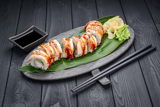 Smok roll sushi z wędzonym węgorzem i krewetkami Tradycyjne pyszne świeże rolki sushi ustawione na czarnym tle Menu sushi Japońska kuchnia restauracja Azjatyckie jedzenie