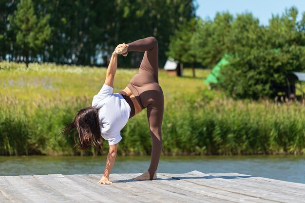 Smukła kobieta ćwicząca jogę wykonująca ćwiczenie Ardha Chandrasana