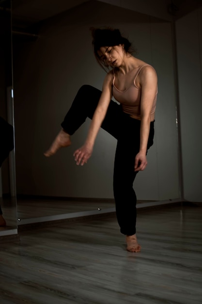 Smukły, elastyczny tancerz taneczny podczas ćwiczeń tanecznych w nowoczesnym studio