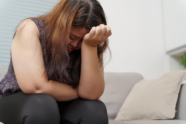 Smutna kobieta z nadwagą plus size myśląca o problemach na kanapie zdenerwowana dziewczyna czuje się samotna i smutna z powodu złego związku lub kobiety z depresją zaburzenia zdrowia psychicznego