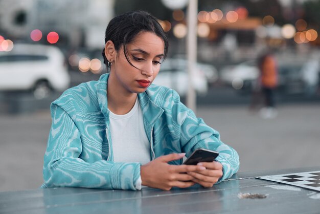 Smutna, Przygnębiona I Zestresowana Kobieta Z Problemami Psychicznymi Wysyłająca Sms-y Na Telefon Siedząc W Kawiarni Na świeżym Powietrzu Młoda Kobieta Otrzymuje Negatywną Odpowiedź Lub Złe Wieści Podczas Rozmowy Lub Przeglądania Mediów Społecznościowych