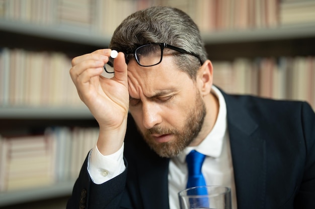 Smutny biznesmen odczuwający straszny ból głowy wyczerpany mężczyzna czuje się niezdrowo zdenerwowany bólem głowy