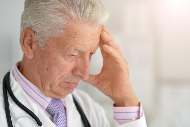 Zdjęcie smutny starszy mężczyzna lekarz pozuje