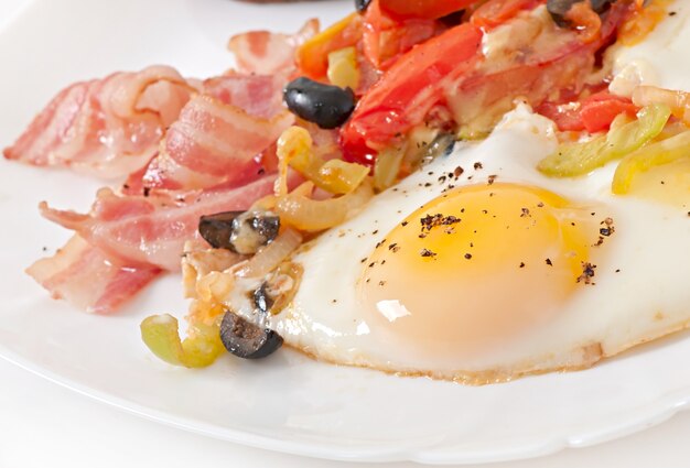 Śniadanie - jajka sadzone z boczkiem, pomidorami, oliwkami i plasterkami sera