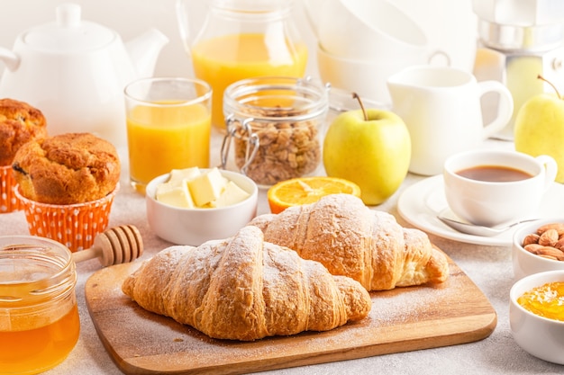 Śniadanie kontynentalne ze świeżymi rogalikami, sokiem pomarańczowym i kawą, selektywne focuse.