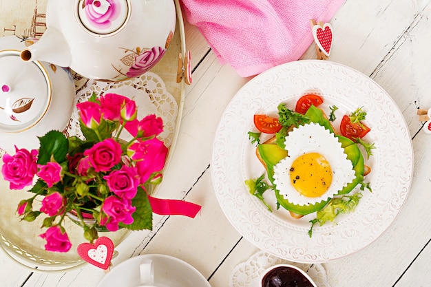 Zdjęcie Śniadanie na walentynki - kanapka z jajkiem sadzonym w kształcie serca, awokado