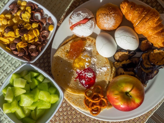 Zdjęcie Śniadanie serwowane z croissantem jajka płatki melon z mlekiem naleśniki jabłkowo-owocowe mieszanka dżemów plastry bakłażana zbilansowana dieta