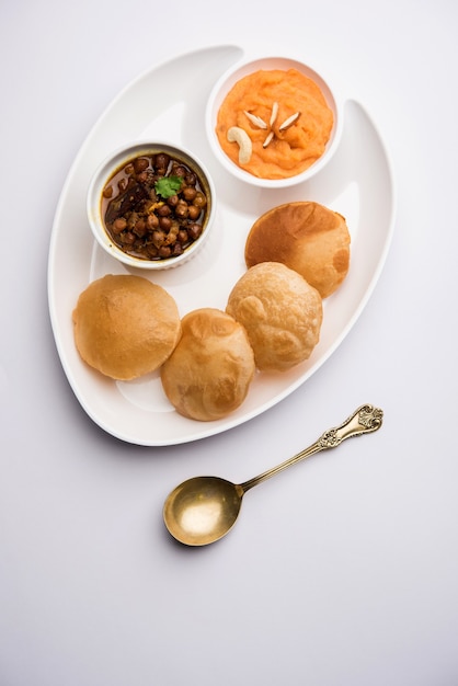 Śniadanie Suji lub Sooji Halwa Puri lub Sheera lub Shira Poori, podawane na talerzu i misce. selektywne skupienie