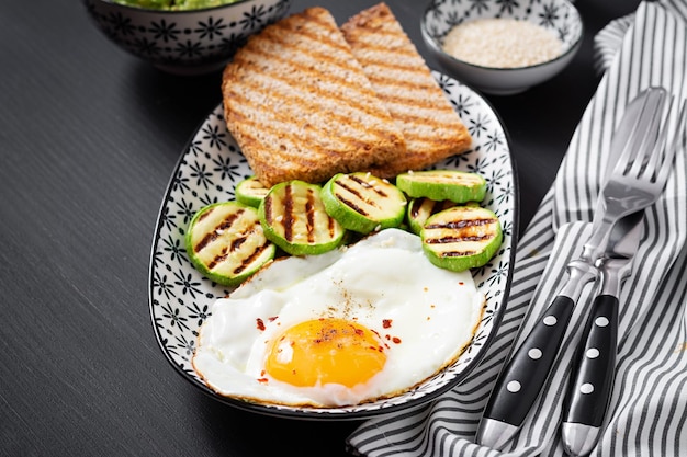 Śniadanie Tosty z awokado guacamole grillowaną cukinią i jajkiem sadzonym Brunch