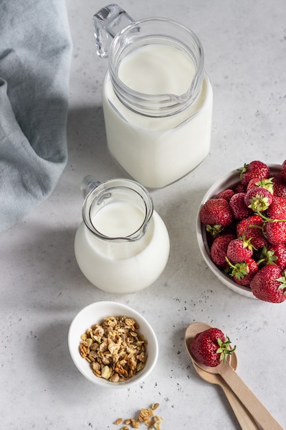 Śniadanie z jogurtem, muesli i świeżą truskawką w słoiku z kamienia