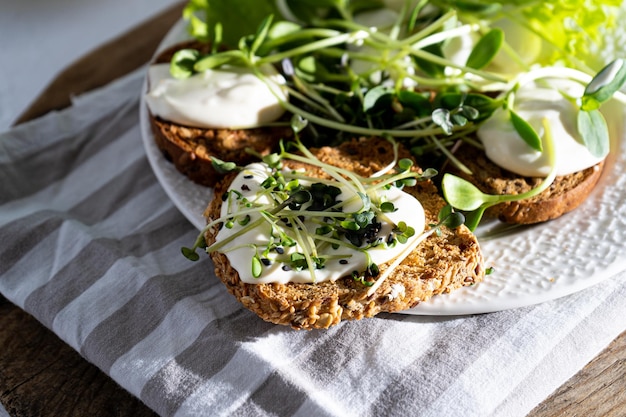 Zdjęcie Śniadanie z mikrogreenem na talerzu chleb tosty ser mozzarella sos śmietanowy jedzenie z zielonymi kiełkami mikrogreena zdrowa dieta proste jedzenie sałatka z kiełkami słonecznika rukola rzodkiewka musztarda