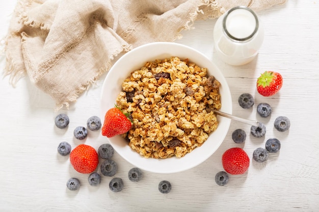 Śniadanie z miską świeżych jagód muesli i butelką mleka