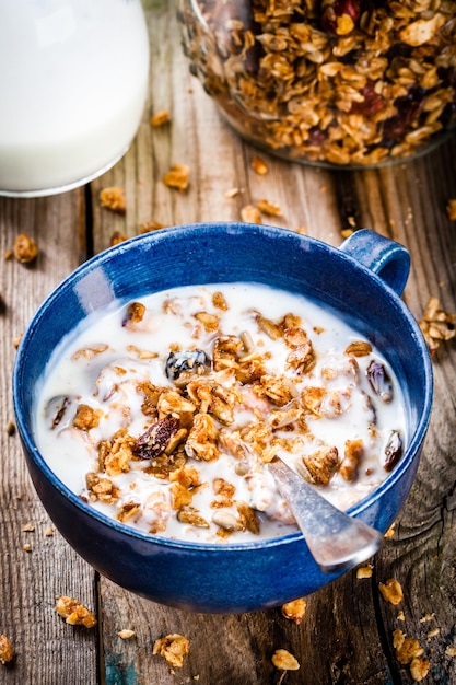 Śniadaniowa domowa granola z jogurtem na drewnianym stole