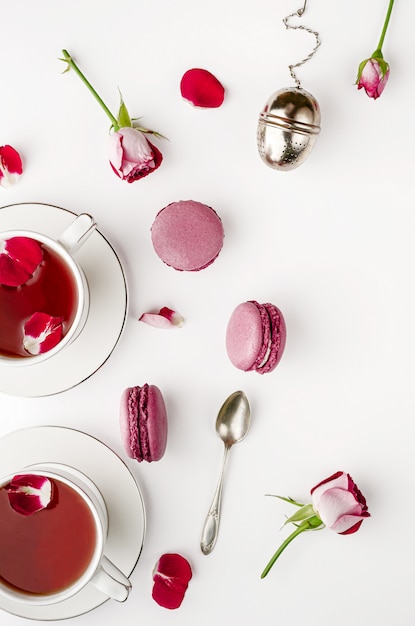 Śniadaniowa herbata na bielu stole z różami i macaroons