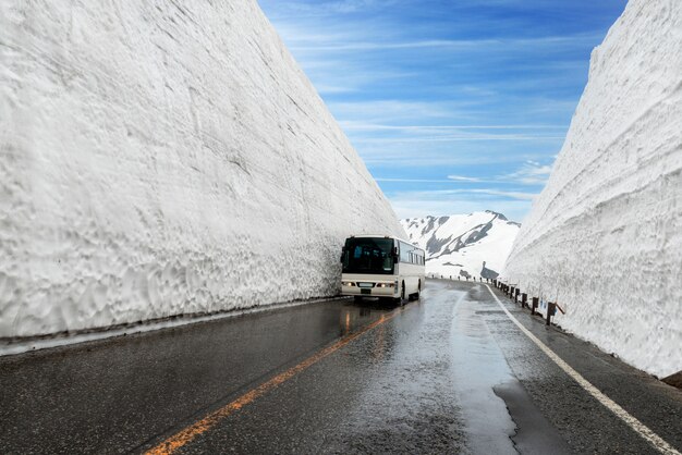 Śnieg ściana przy Kurobe wysokogórskim w Japonia z autobusem dla turystów na Tateyama Kurobe Alpejskiej trasie