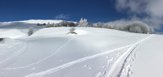 Śnieżna góra Beautidul ze śladami pod błękitnym niebem