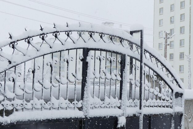 Śnieżne krajobrazy w zimie śnieg padający na żelazną bramę wspaniałe obrazy stworzone przez śnieżne śnieżne krajobrazy