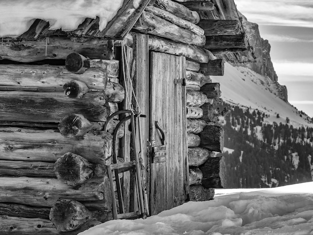 Śnieżne sanie na zewnątrz drewnianej chatki w zimie w bw
