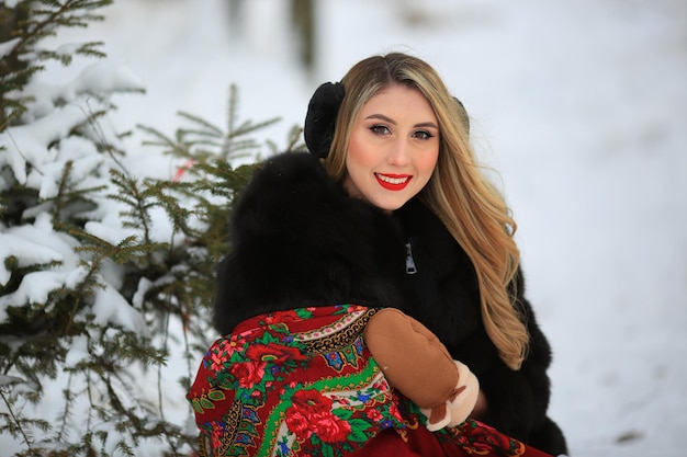 Zdjęcie snow maiden w zimowym lesie z uśmiechem na twarzy i czerwoną szminką