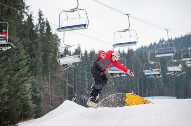 Snowboarder leci w dół z przeszkody w zimowy dzień