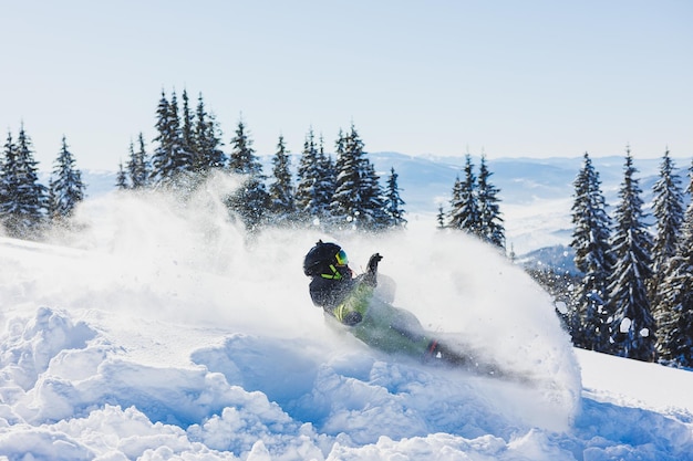 Snowboardzista idzie w dół zaśnieżonym zboczu w zimie na śniegu Freeride zimą na snowboardzie