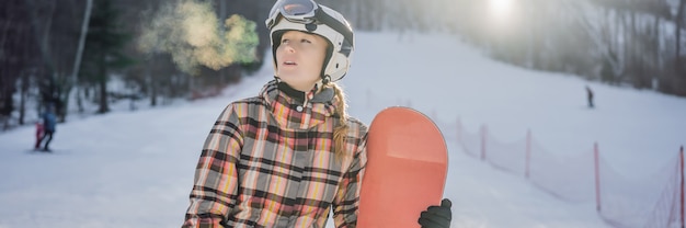 Snowboardzista kobieta w słoneczny zimowy dzień w ośrodku narciarskim