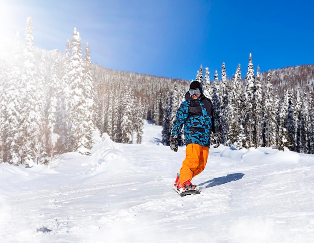 snowboardzista zjeżdża ze stoku w słoneczny dzień