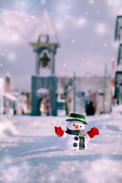 Snowman stoją wśród stos śniegu. Płatek śniegu spada. Wesołych Świąt i szczęśliwego ne
